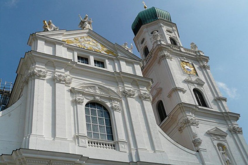 A white building with a green dome and a clock tower. 5