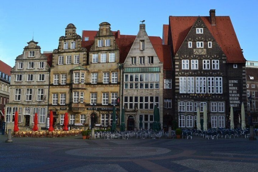 Historic European buildings with red-tiled roofs and a clear blue sky. 4