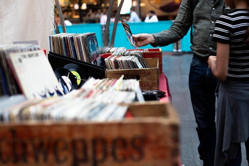 Een straatverkoper verkoopt platen op een markt. 2