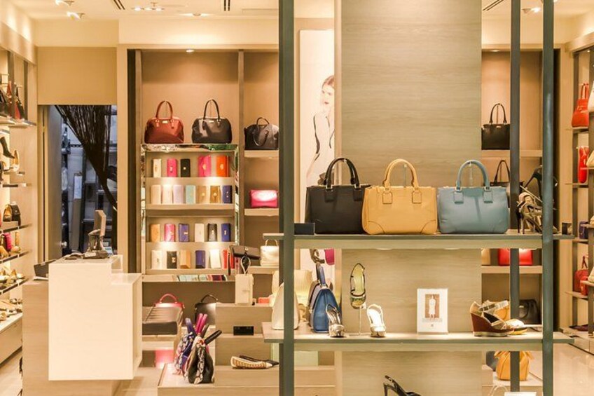 Een luxe handtaswinkel met schappen vol handtassen en accessoires. 1