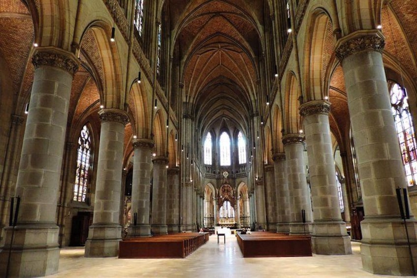 L’intérieur d’une cathédrale, avec de hauts plafonds en voûte, de grandes fenêtres à vitraux et de hautes colonnes en pierre. 4