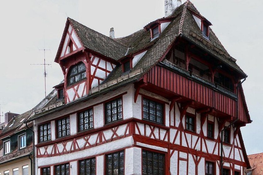 Une maison traditionnelle à colombages, dotée d’un toit à forte pente et de nombreuses fenêtres. 4