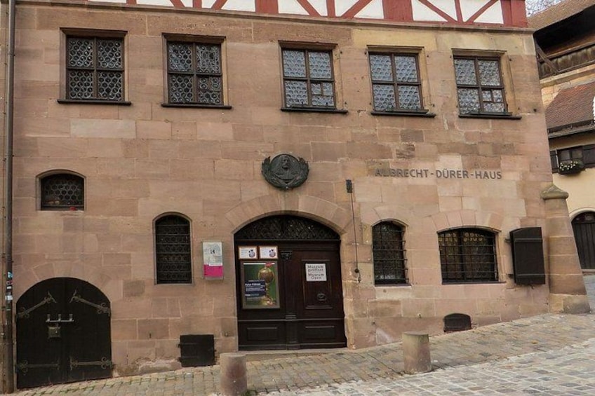 Un bâtiment historique doté d’une façade en pierre, de fenêtres en arc de cercle et d’une porte imposante. 2