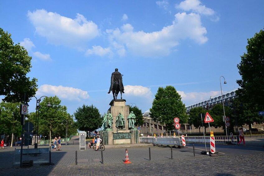 A statue, traffic signs, and a pedestrian crossing in an urban setting. 1