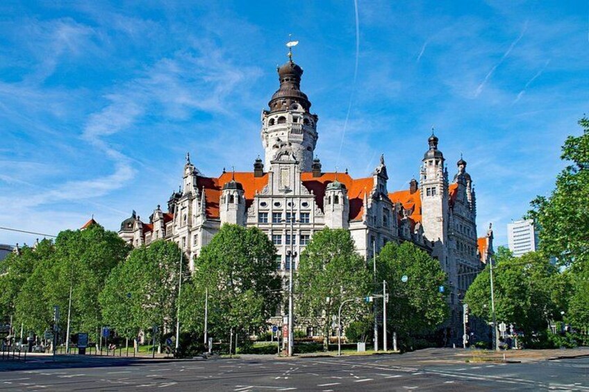 A historic building with ornate architecture, a prominent tower, and a clear blue sky. 5