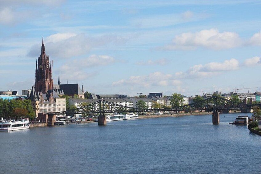 A river with a bridge, a cathedral, and boats. 2