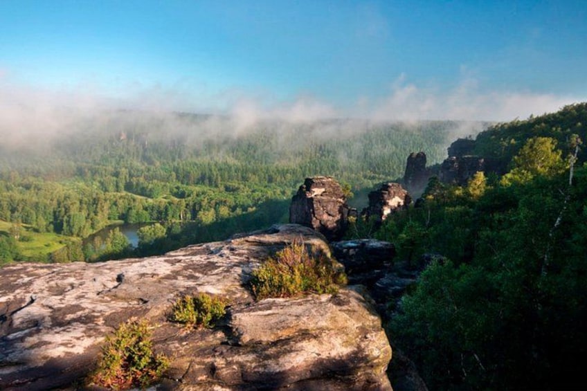 Een bergachtig landschap met rotsformaties en dicht bos. 3