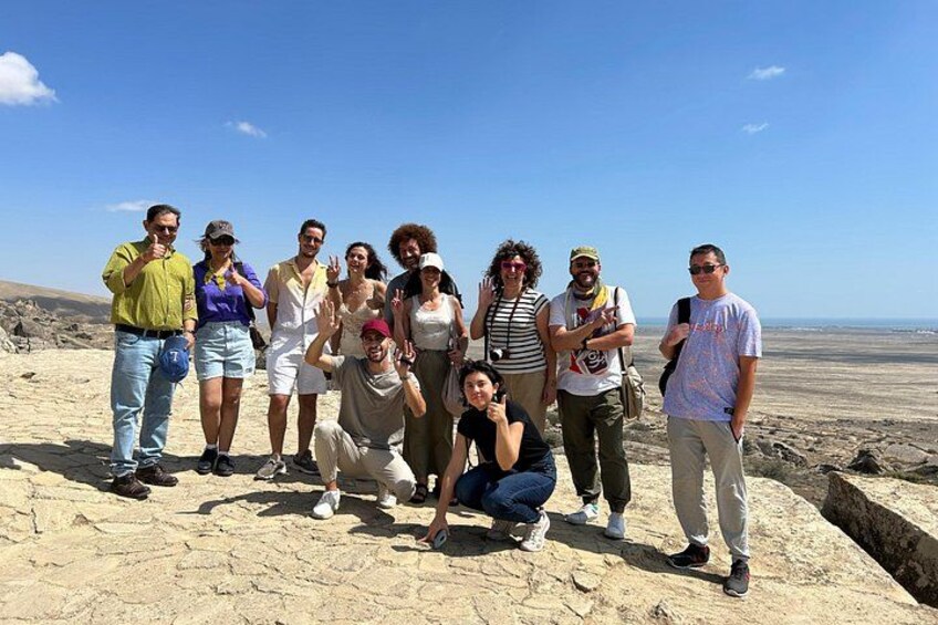 A group of people standing on a rocky terrain with a clear sky. 3