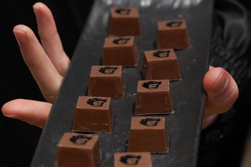 Een hand die een schaal met chocoladerepen vasthoudt. 2