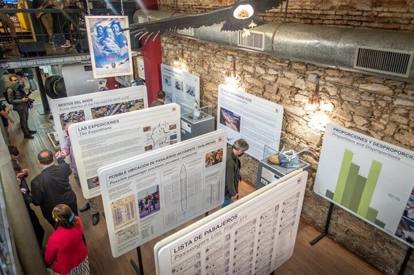 Exhibición interior con paneles informativos y un fondo de pared de piedra. 1
