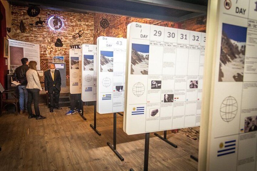 A museum exhibit with informational panels, a brick wall, and a wooden floor. 5