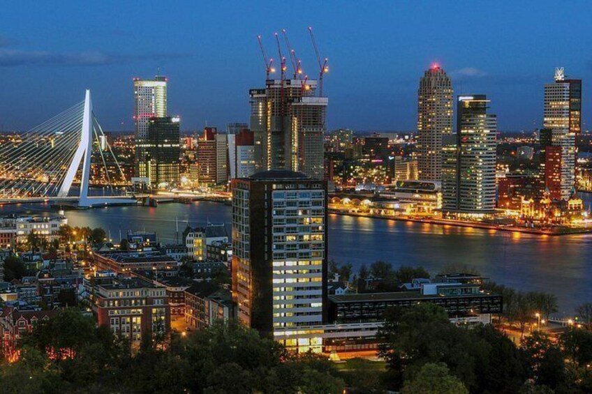 A city skyline with modern buildings, a prominent cable-stayed bridge, and a river. 3