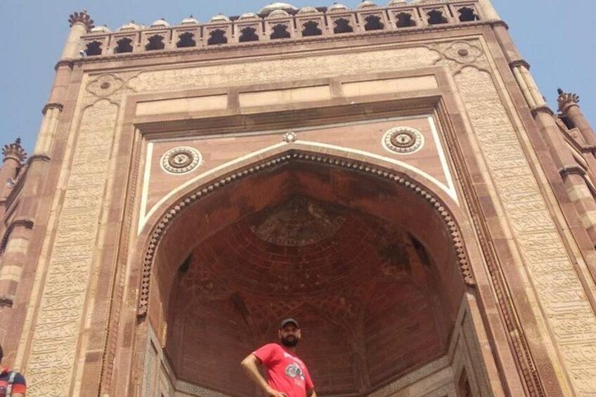 A large archway with intricate carvings and a clock at the top. 5