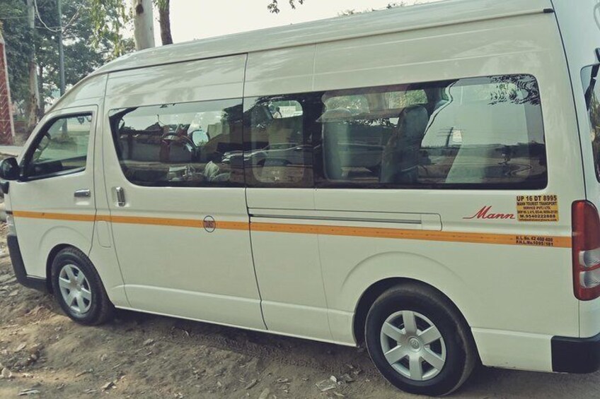 A white van with orange stripes parked on a dirt road. 2