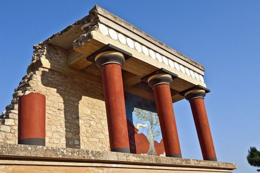 Un temple grec antique, doté de colonnes rouges et d’une frise. 1