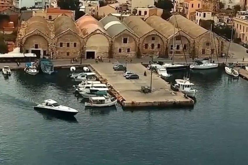 Un port où sont amarrés des bateaux, un grand bâtiment doté d’arcs en plein cintre et une promenade en bord de mer. 5