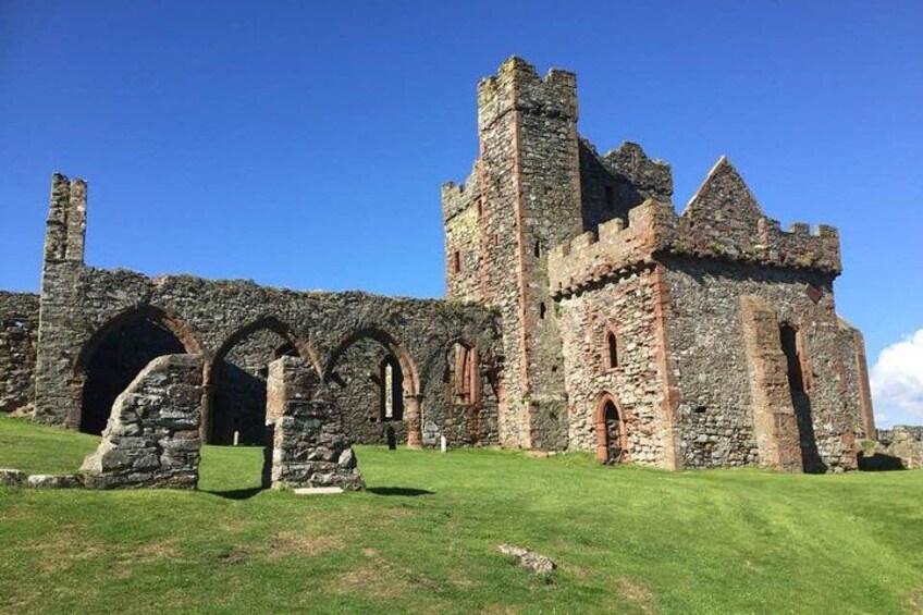 A historic stone building with arches and towers. 1