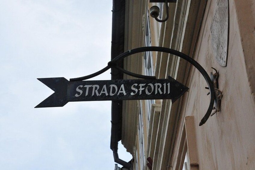 Una señal de calle para 'Strada Sforii' colocada en un edificio. 5