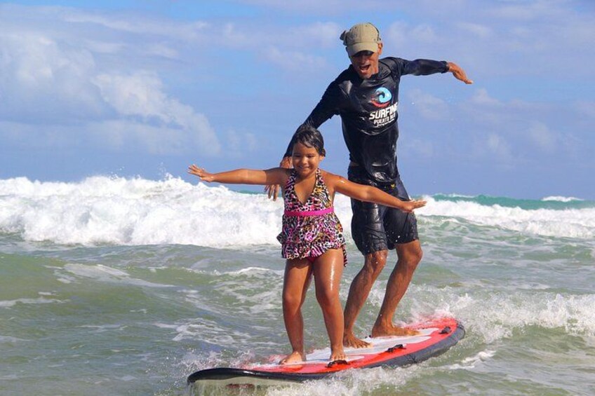 Une personne faisant de la planche à voile avec un enfant sur une vague. 2