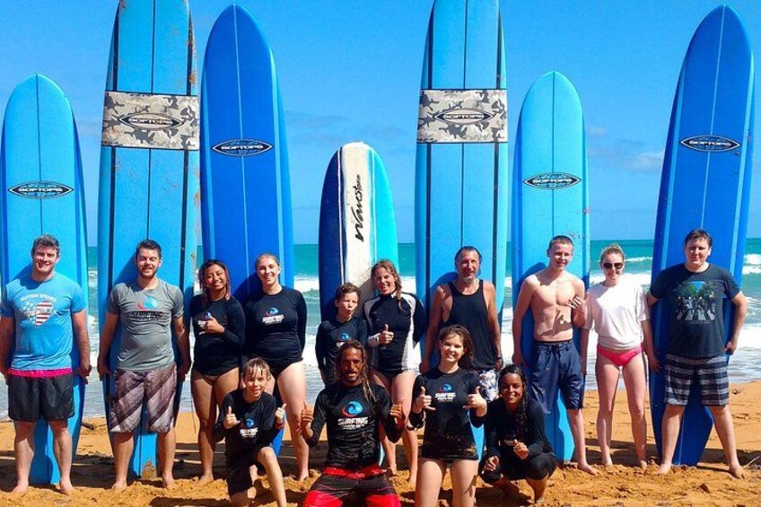 Un groupe de personnes sur une plage, avec des planches de surf. 1