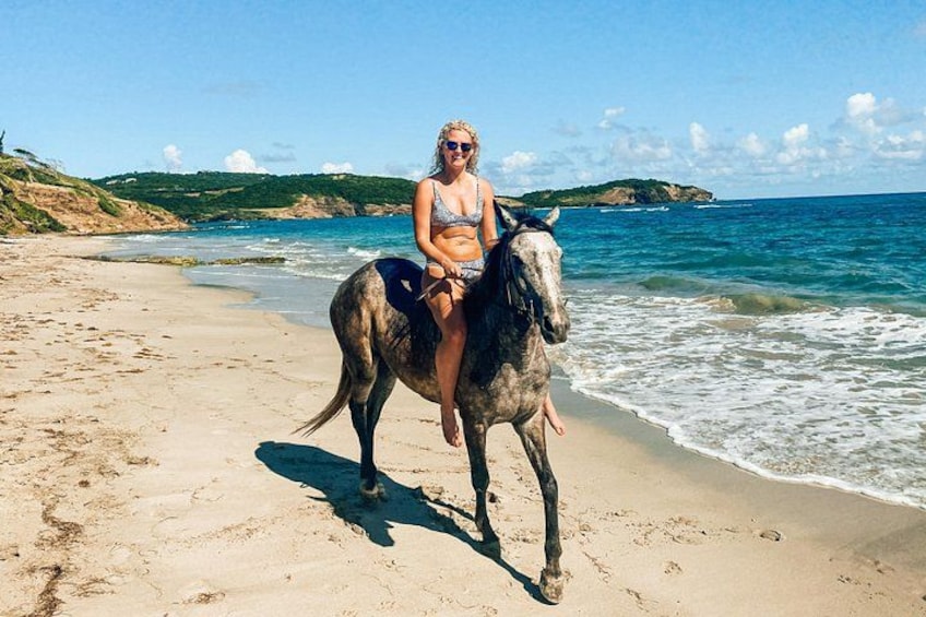 Lady horseback riding along the beach. 4