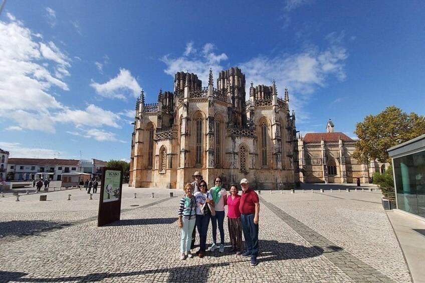 A historic cathedral with intricate architecture, a cobblestone plaza, and a clear blue sky. 4