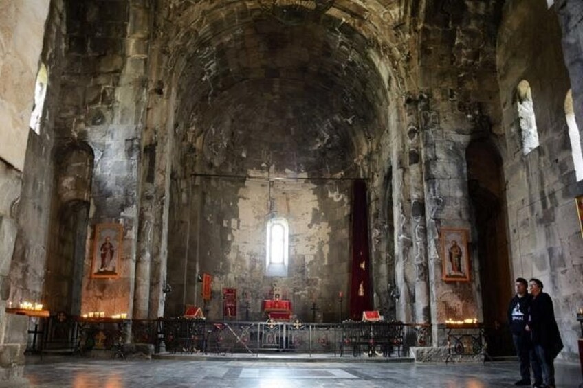 Het interieur van een oude kerk, met gewelfde plafonds, stenen muren en religieuze iconen. 3