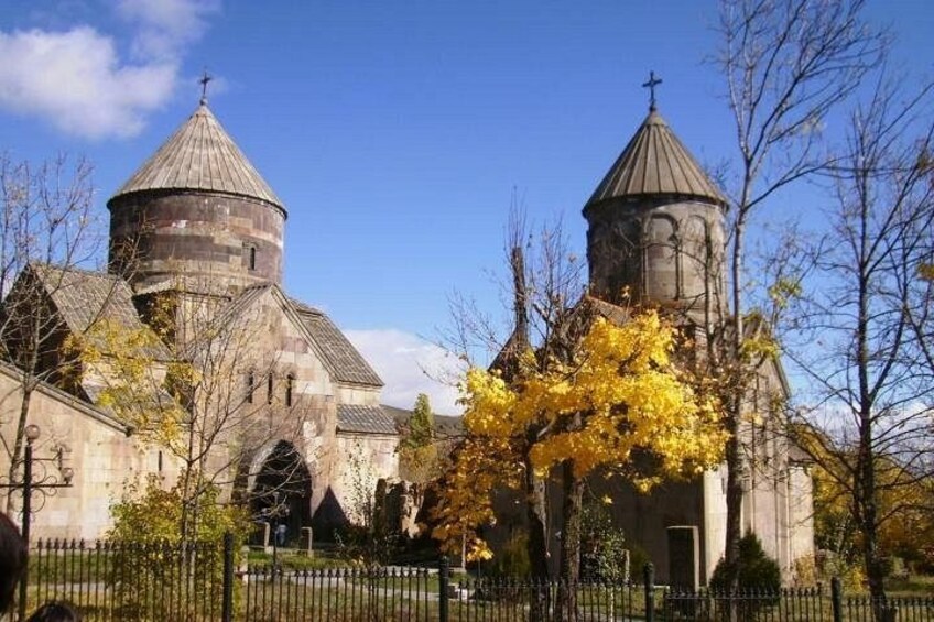 Una chiesa con due cupole, circondata da alberi dai fogliami gialli. 3