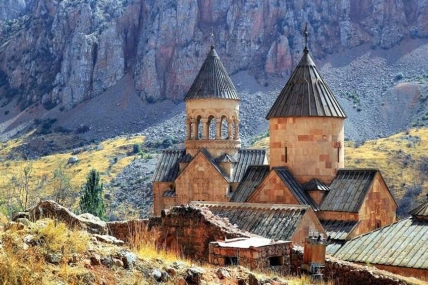 Eine Kirche mit zwei Türmen, umgeben von einer gebirgigen Landschaft. 2