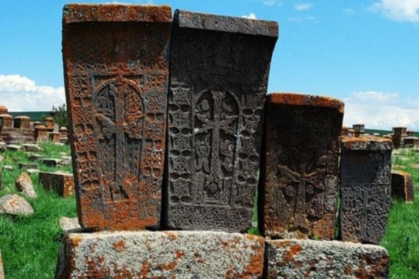 D’anciennes constructions en pierre, ornées de sculptures complexes, se dressent au milieu d’un champ verdoyant. 3