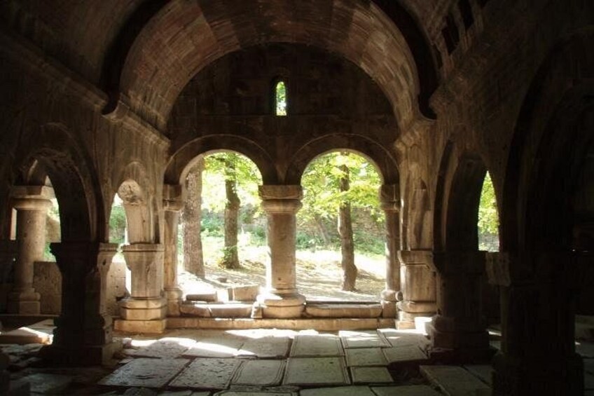 An ancient stone structure with arches and columns, sunlight filtering through. 3