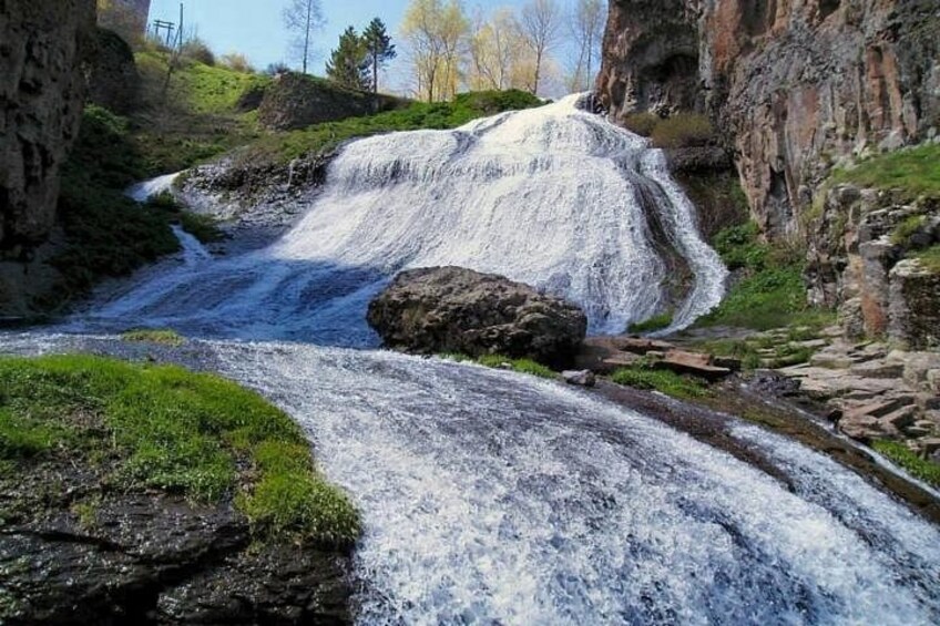 A waterfall cascading over rocks in a natural setting. 2