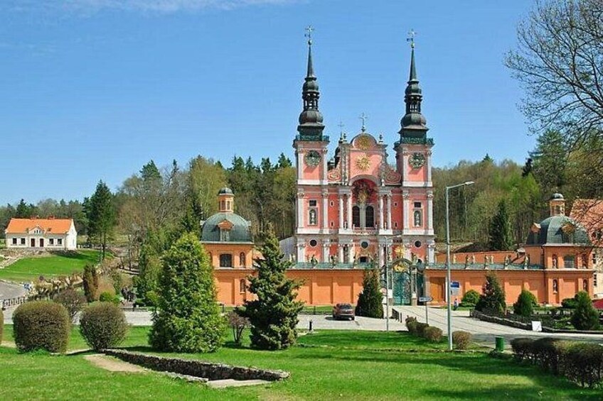 A church with two towers, surrounded by greenery and a clear sky. 2