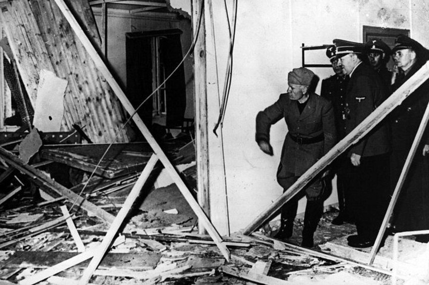 A damaged building with debris and a group of men in military uniforms. 2