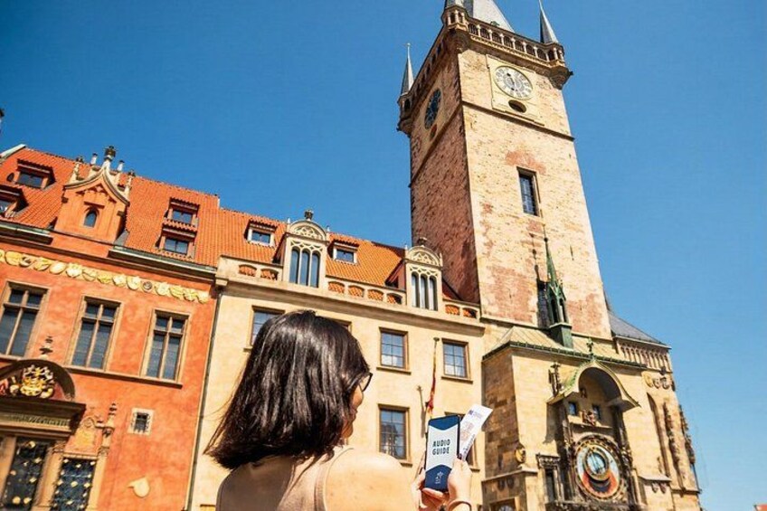 Un edificio histórico con una torre de reloj y una persona sosteniendo un mapa. 1
