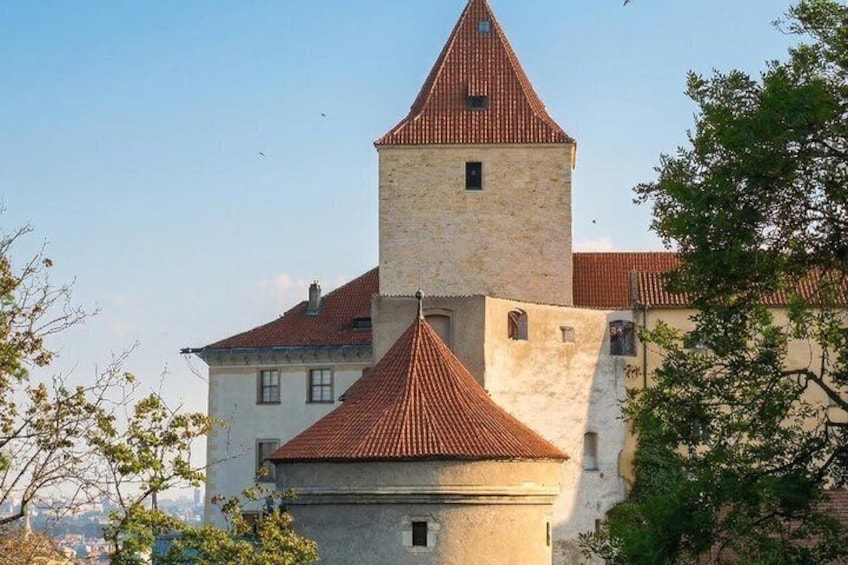 A castle with a prominent tower and red-tiled roofs. 2