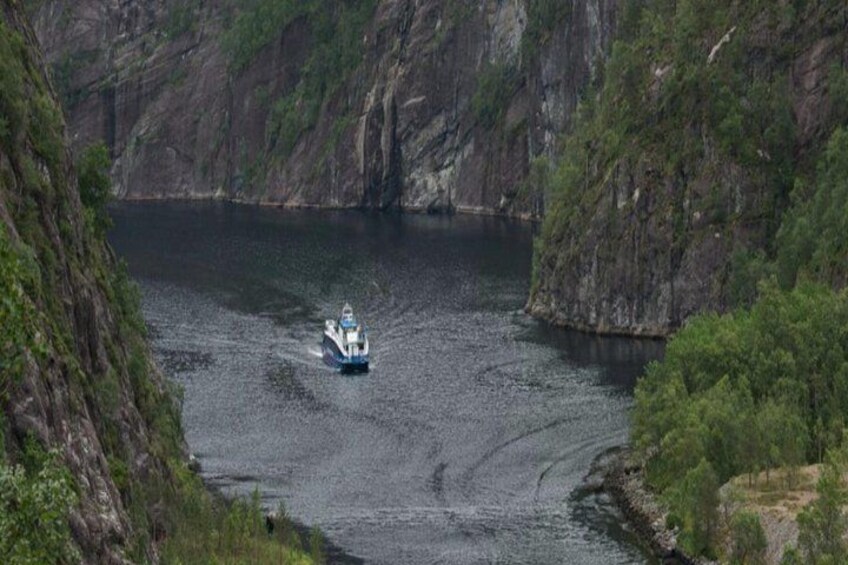 Una barca su un fiume, circondata da alte scogliere. 5
