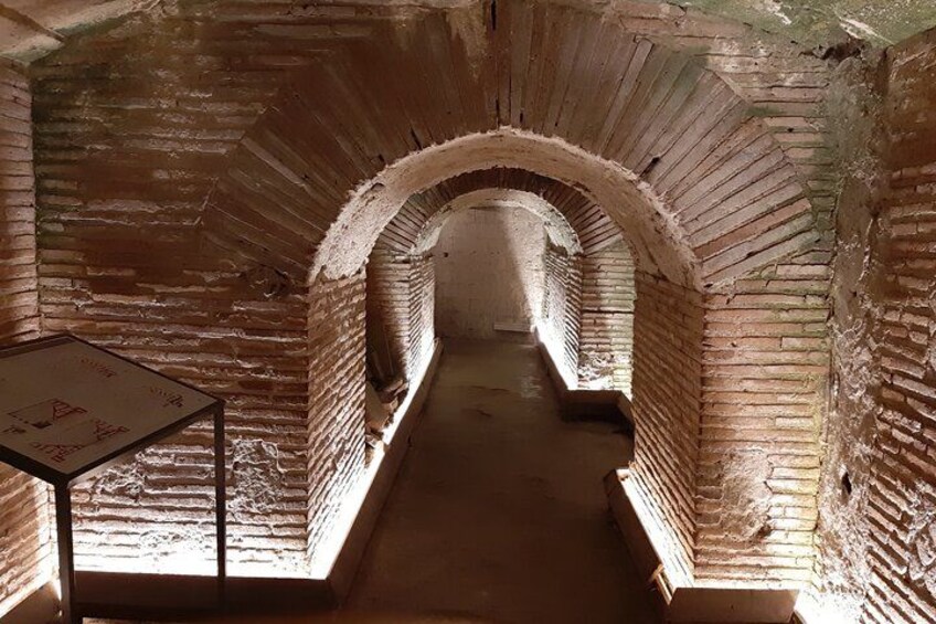 A brick tunnel with arched ceilings and a signboard. 3