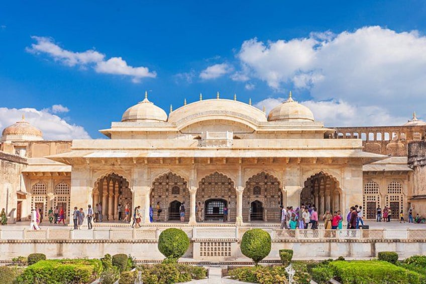 A historic building with domes and arches, surrounded by a well-maintained garden. 2