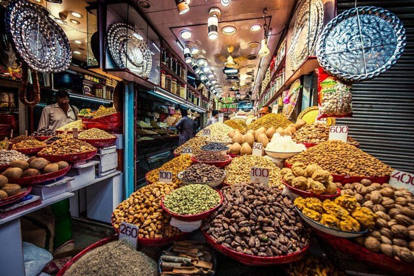 A market with various food items displayed in bowls and baskets, with price tags visible. 4