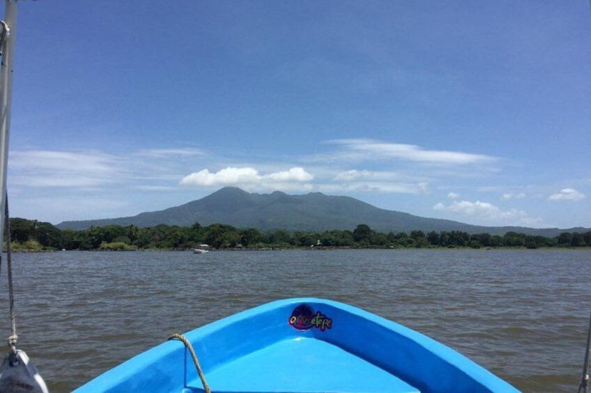 A blue boat on calm water with a mountain in the background. 3