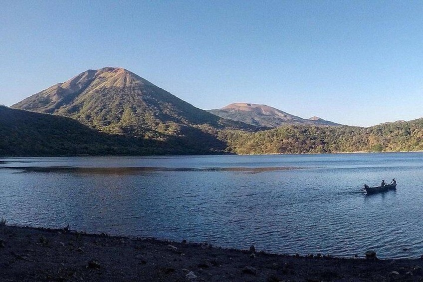 Un lago con un bote, una montaña y un cielo despejado. 2