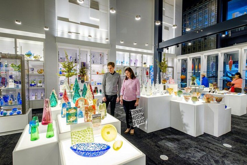 Une exposition dans un musée présentant des œuvres d’art en verre et accueillant des visiteurs. 2