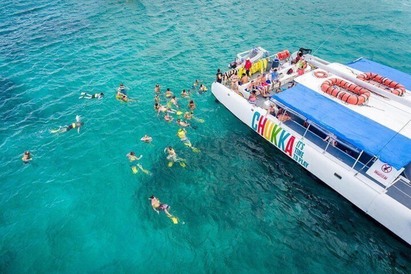 Un bote con gente haciendo snorkel en el agua. 4