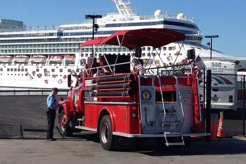 A red fire truck parked in front of a cruise ship. 3