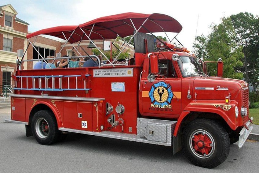 A red fire truck with a canopy, parked on a street. 2