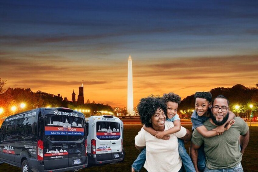 En familie med et barn foran et stort monument, sandsynligvis Washington Monument, med to busser i baggrunden. 2