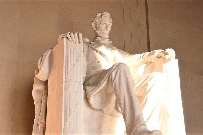 A marble statue of a seated figure with a draped cloth. 4