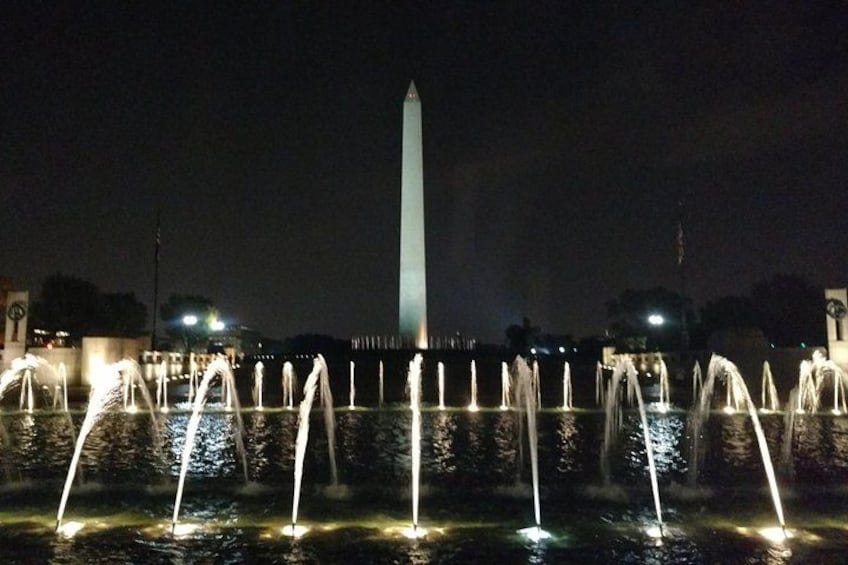 A night scene with a lit fountain and the Washington Monument in the background. 3