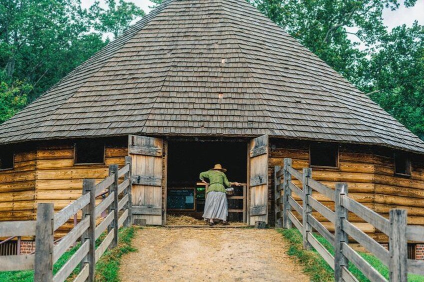 Dressed in period clothing, a guide opens Washington's 16-sided treading barn to visitors. 2